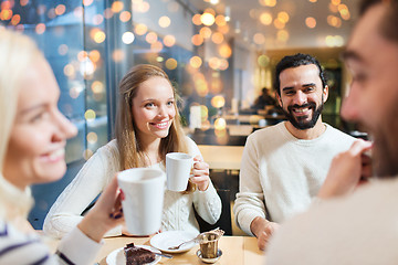 Image showing happy friends drinking tea at cafe