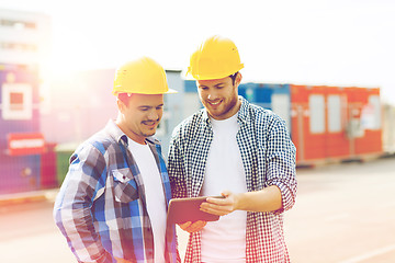 Image showing two smiling builders in hardhats with tablet pc