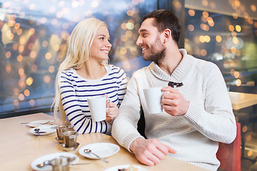 Image showing happy couple drinking tea or coffee at cafe