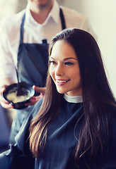 Image showing happy young woman coloring hair at salon