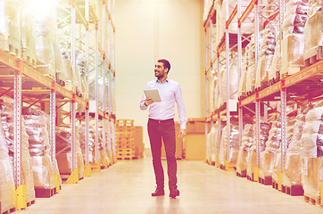 Image showing happy businessman with tablet pc at warehouse