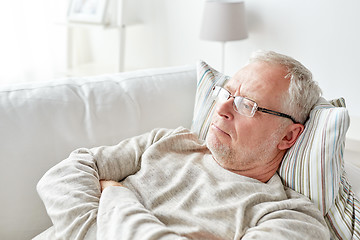 Image showing close up of senior man in glasses thinking at home