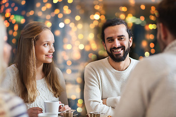 Image showing happy friends drinking tea at cafe