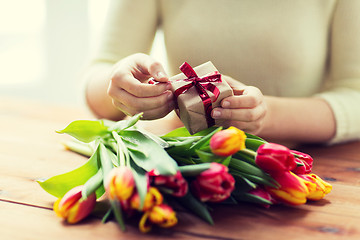 Image showing close up of woman with gift box and tulip flowers