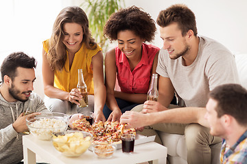 Image showing happy friends with drinks eating pizza at home