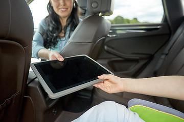 Image showing woman giving tablet pc to her child in car