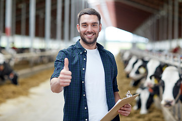 Image showing farmer with cows showing thumbs up on dairy farm