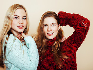 Image showing Two young girlfriends in winter sweaters indoors having fun. Lif