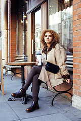 Image showing young pretty african american women drinking coffee outside in c