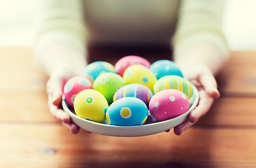 Image showing close up of woman hands with colored easter eggs