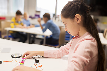 Image showing happy girl building robot at robotics school