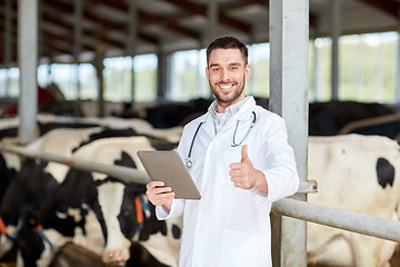 Image showing veterinarian with tablet pc and cows on dairy farm