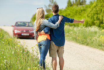 Image showing couple hitchhiking and stopping car on countryside