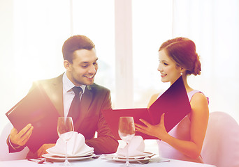 Image showing smiling couple with menus at restaurant