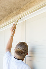 Image showing Professional Painter Cutting In With Brush to Paint Garage Door 