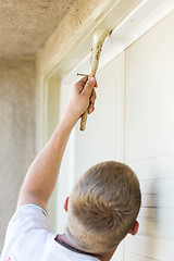 Image showing Professional Painter Cutting In With Brush to Paint Garage Door 