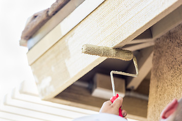 Image showing Professional Painter Using Small Roller to Paint House Fascia