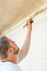 Image showing Professional Painter Cutting In With Brush to Paint Garage Door 