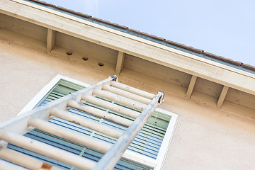 Image showing Construction Ladder Leaning Against House