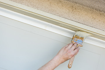 Image showing Professional Painter Cutting In With Brush to Paint Garage Door 