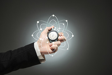 Image showing hand holding a stopwatch against  white background