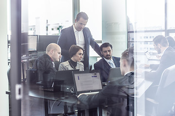 Image showing Business team working in corporate office seen trougt glass door.