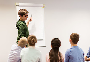 Image showing student boy with marker writing on flip board