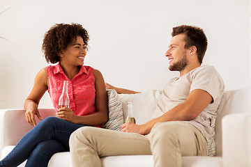 Image showing happy friends or couple with beer talking at home