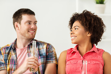 Image showing happy friends or couple with beer talking at home