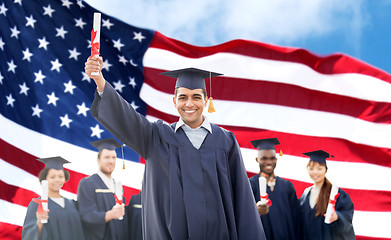 Image showing happy students in mortarboards with diplomas