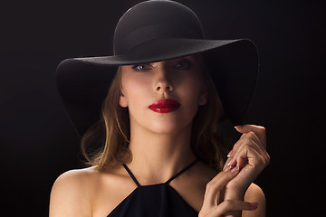 Image showing beautiful woman in black hat over dark background