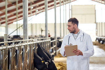 Image showing veterinarian with cows in cowshed on dairy farm