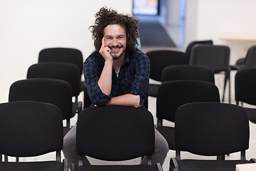 Image showing A student sits alone  in a classroom