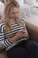 Image showing woman sitting on sofa with mobile phone