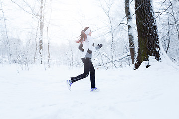 Image showing Girl jogging in winter woods