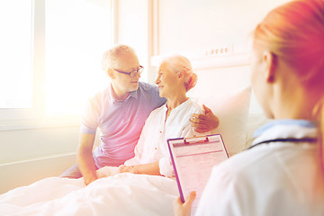 Image showing senior woman and doctor with clipboard at hospital