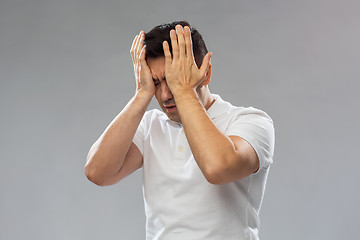 Image showing unhappy man suffering from head ache