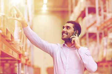 Image showing happy man calling on smartphone at warehouse