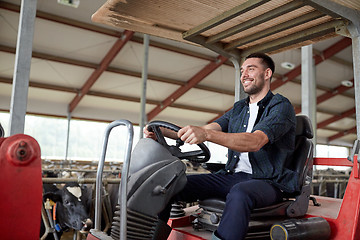 Image showing man or farmer driving tractor at farm