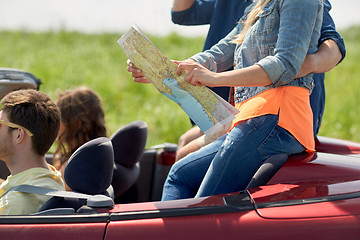 Image showing happy friends with map driving in convertible car