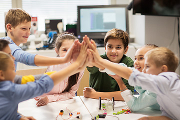 Image showing happy children making high five at robotics school