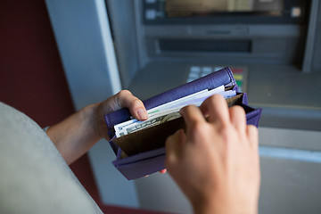 Image showing close up of hands with money at atm machine