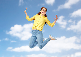 Image showing smiling young woman jumping in air