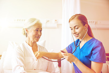 Image showing nurse with stethoscope and senior woman at clinic