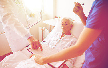 Image showing doctor and nurse visiting senior woman at hospital