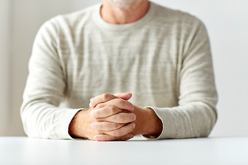 Image showing close up of senior man hands on table