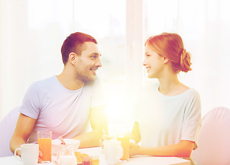 Image showing smiling couple having breakfast at home