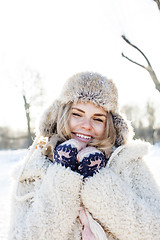 Image showing young pretty teenage hipster girl outdoor in winter snow park having fun drinking coffee, warming up happy smiling, lifestyle people concept