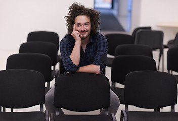 Image showing A student sits alone  in a classroom