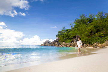 Image showing A beautiful woman walking on the beach